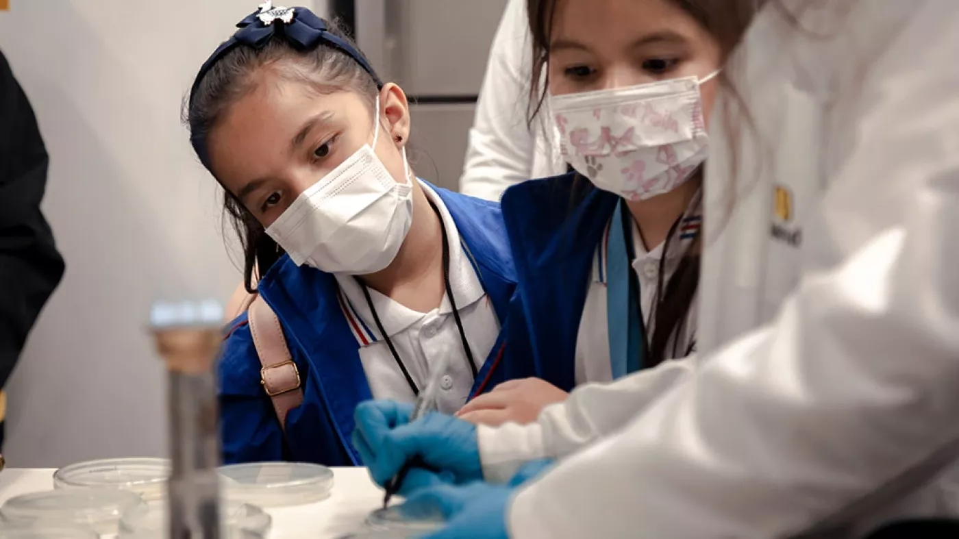 Niña mirando por un microscopio