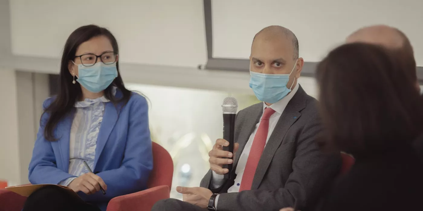 Dos personas hablando en un panel.