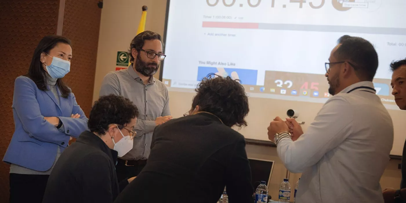 Dos personas dialogan con un grupo de otros tres.