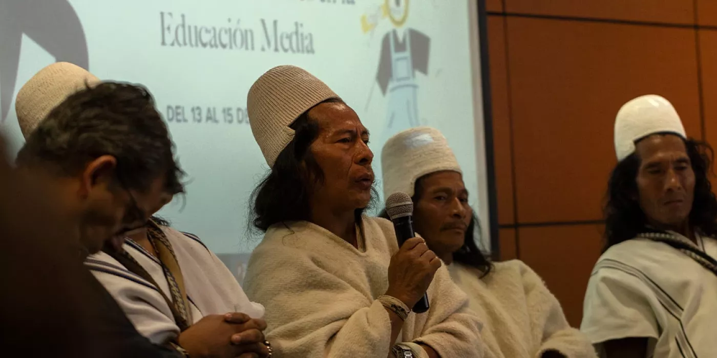 Hombres indígenas, sentados. 