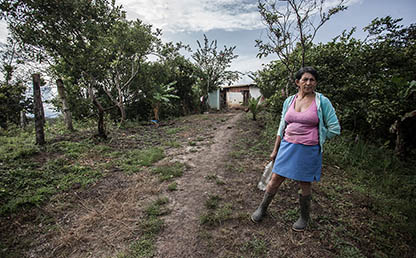 Retrato de una señora del campo parada frente a su casa