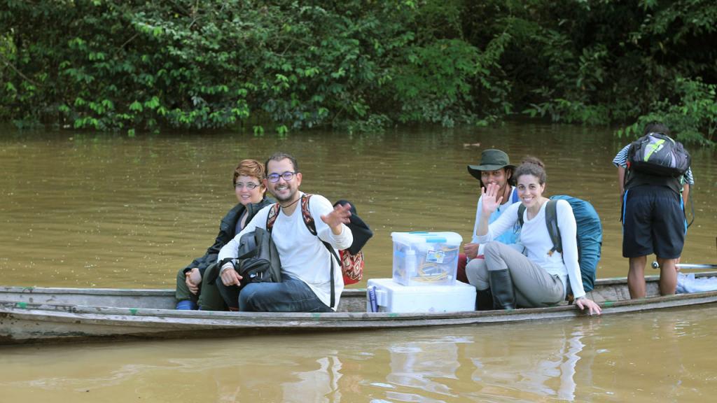 Cuatro personas navegan en una canoa por el río Amazonas