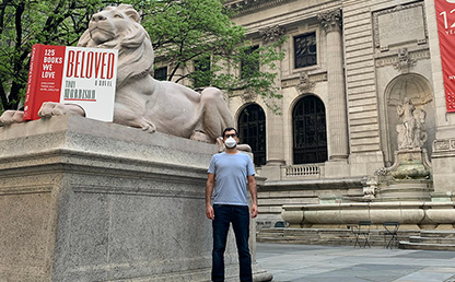 Daniel Téllez posa frente a uno de los leones a la entrada de la Biblioteca Pública de Nueva York.
