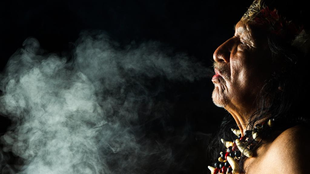 Hombre indígena fumando tabaco. 
