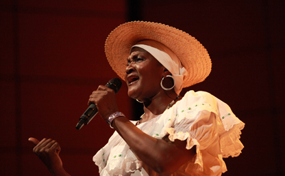Mujer afrodescendiente canta en un auditorio