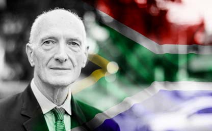 Hombre con la bandera de Sudáfrica de fondo.