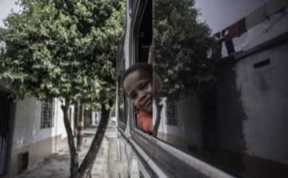 Niño asoma su cabeza por la ventana de un bus