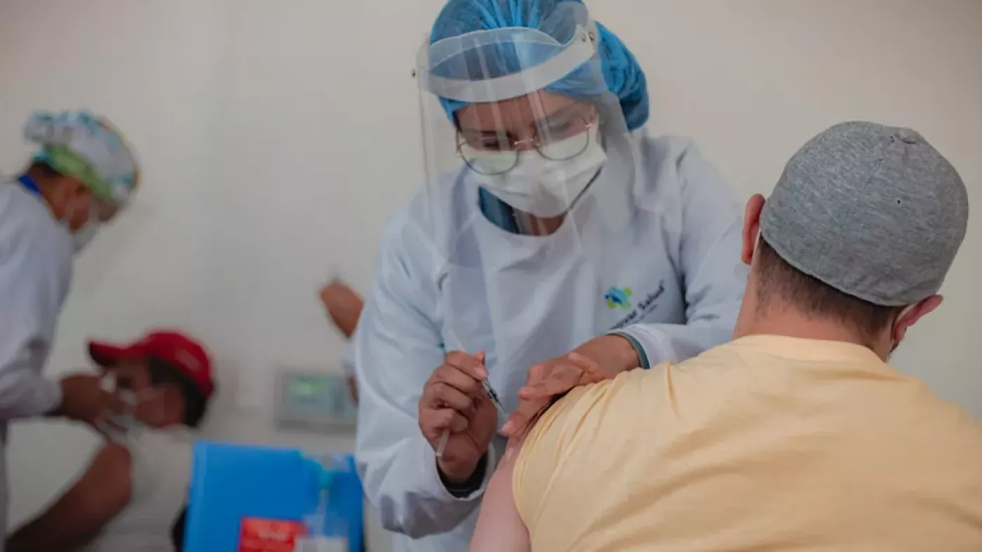 Trabajadora de la salud vacunando a un hombre