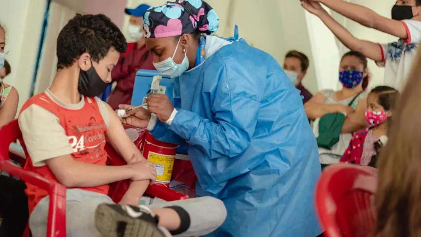 Trabajadora de la salud vacunando a un joven