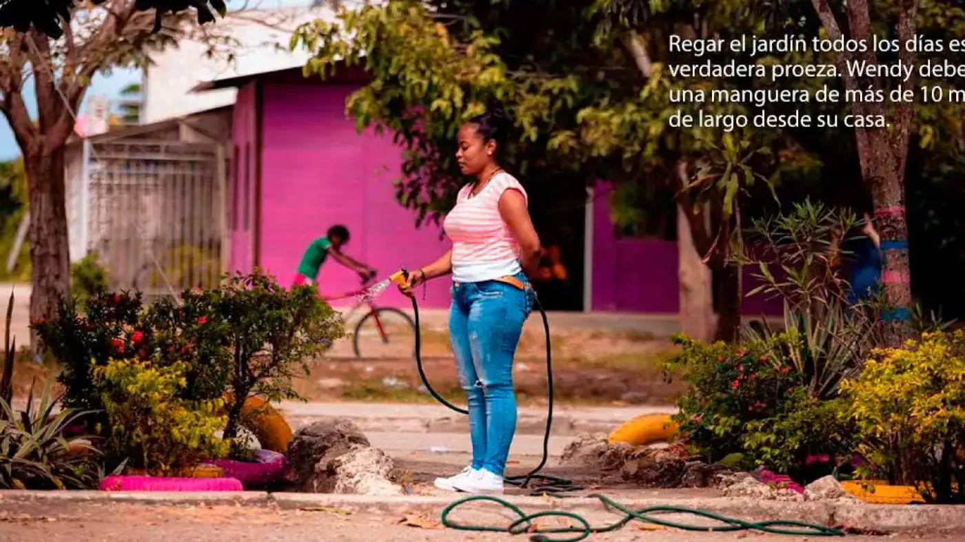 Mujer riega un jardín en Cartagena