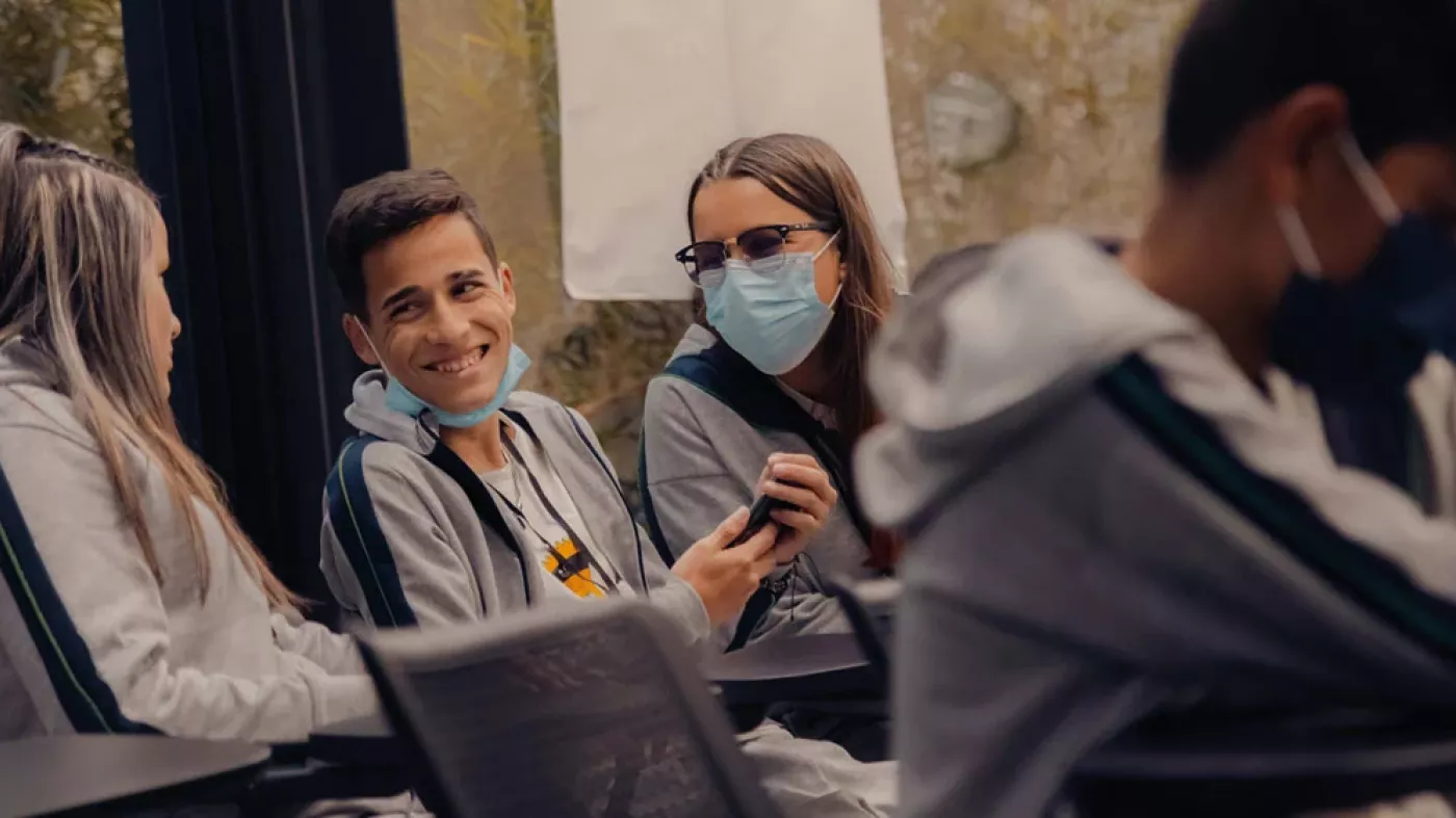 Estudiantes de colegio sonríen y conversan