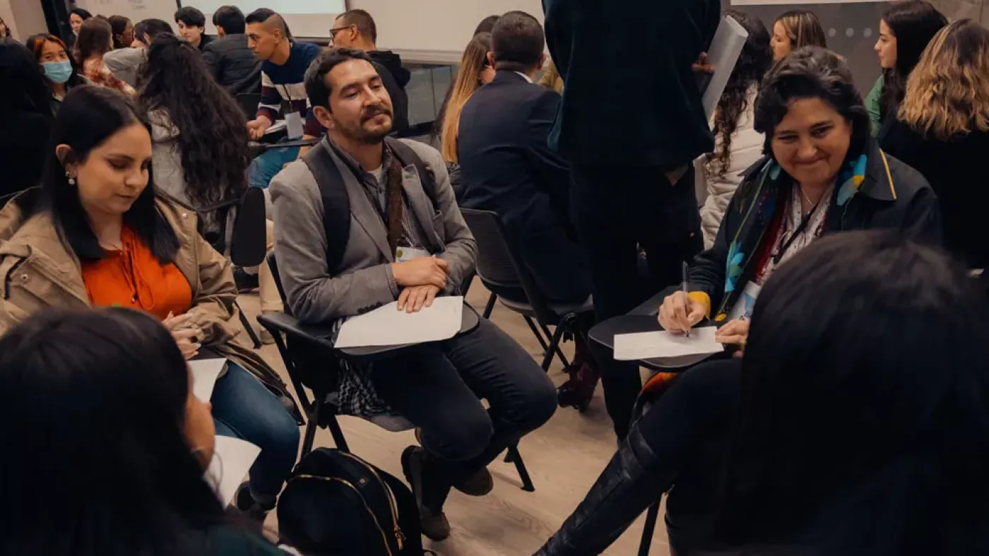 Hombres y mujeres sentados en círculo.