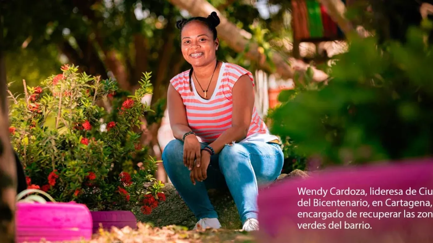 Mujer agachada en un jardín.