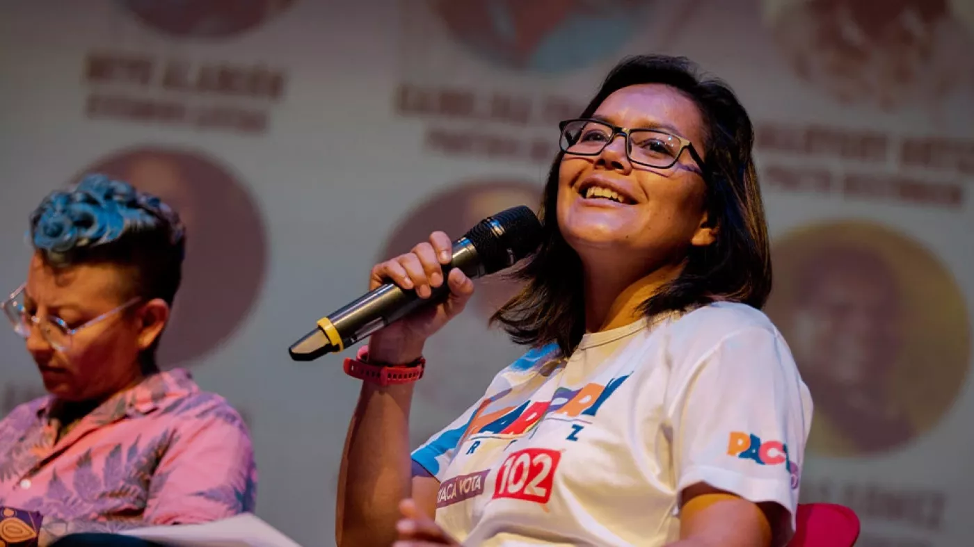 Mujer hablando con un micrófono.