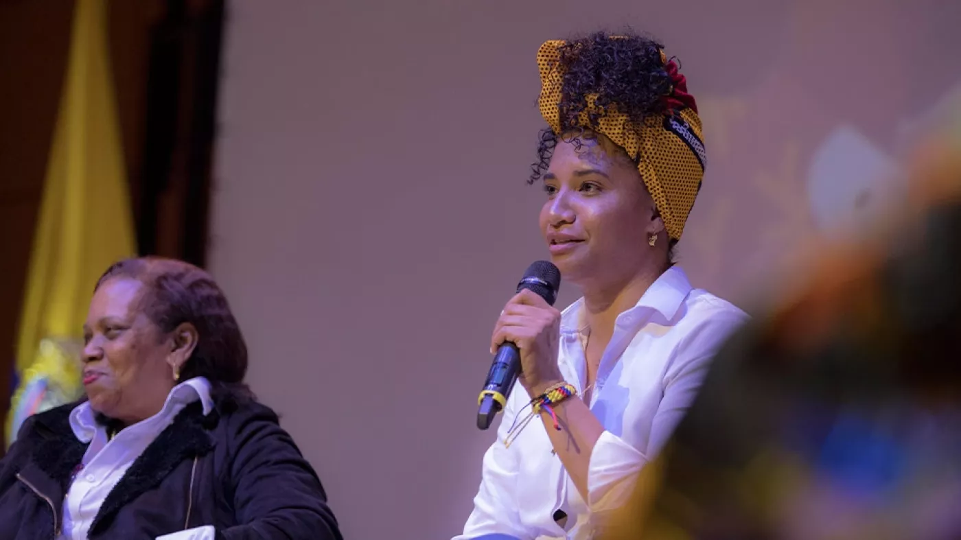 Mujeres negras hablando en un escenario.