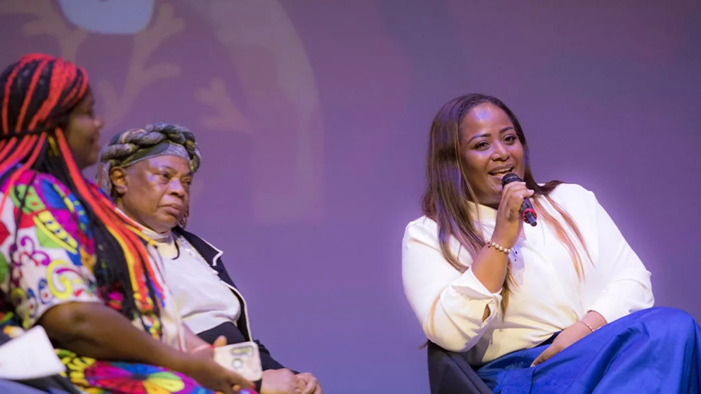 Mujeres negras hablando en un escenario.