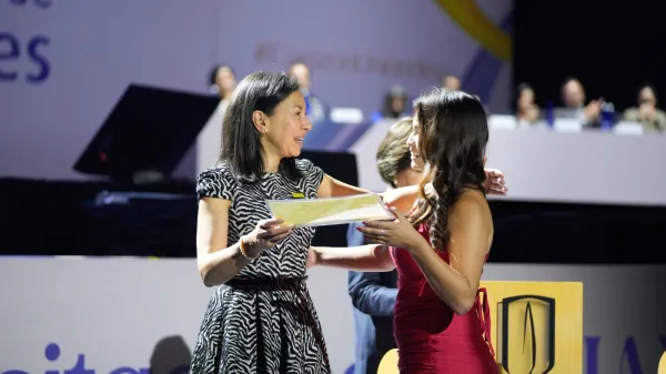 La rectora, Raquel Bernal, le entrega el reconocimiento de responsabilidad social a Lina.