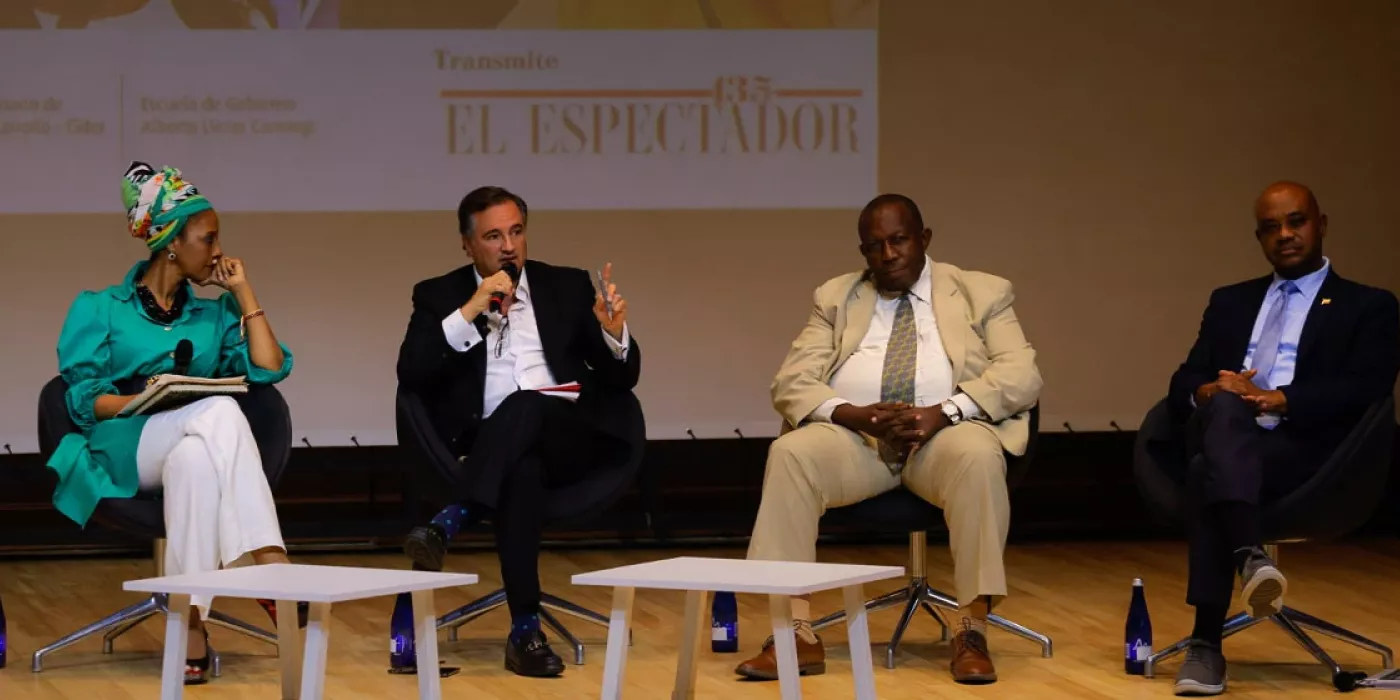 Hombres y mujeres, sentados en un auditorio. 
