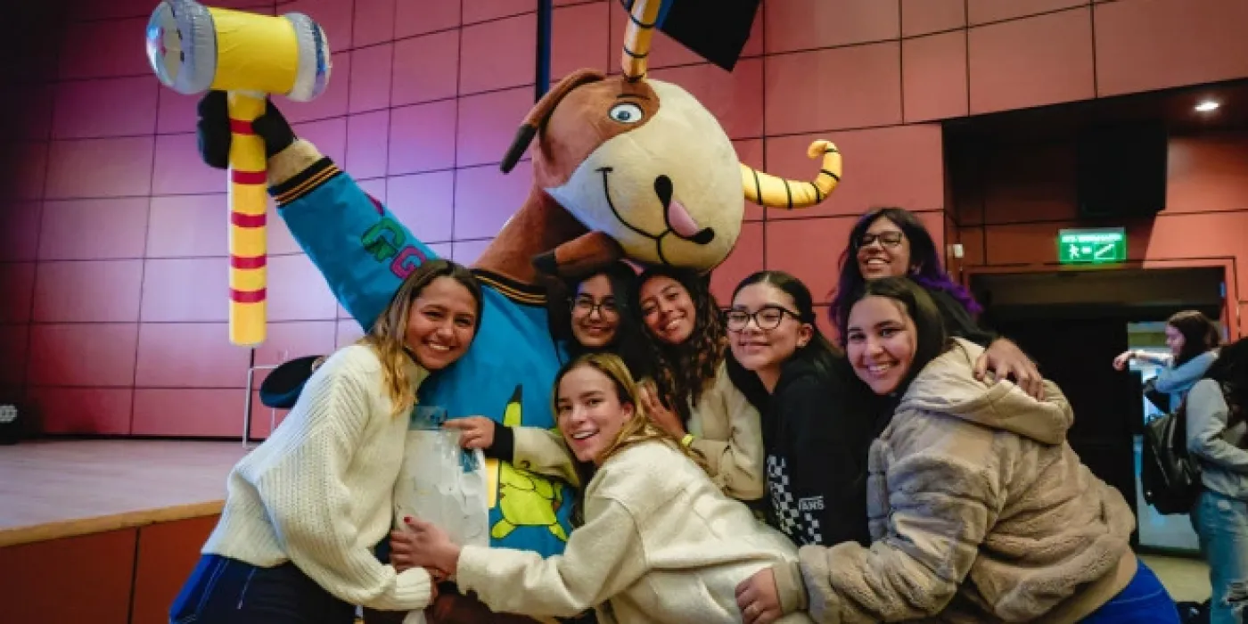 Grupo de estudiantes de Universidad de los Andes abrazados y sonrientes