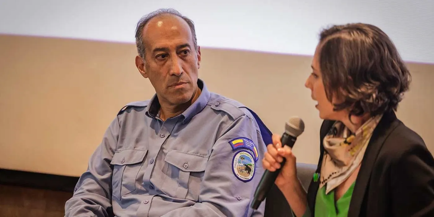 Dos personas hablan en un auditorio.